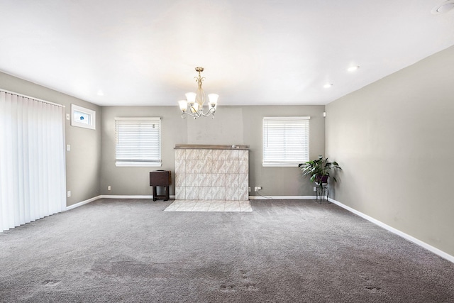 unfurnished living room with a notable chandelier, carpet, and plenty of natural light
