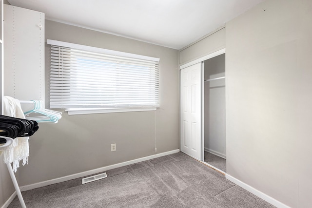 unfurnished bedroom with baseboards, visible vents, a closet, and carpet flooring