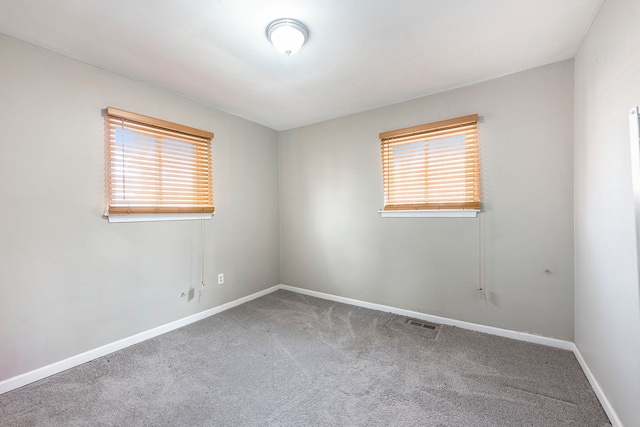 empty room featuring baseboards and carpet flooring
