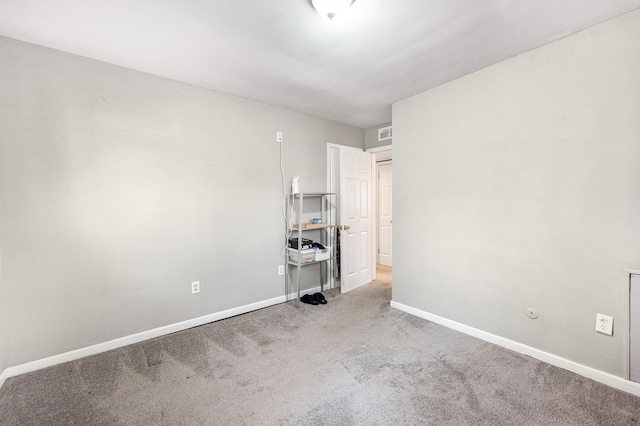 unfurnished room with baseboards, visible vents, and carpet