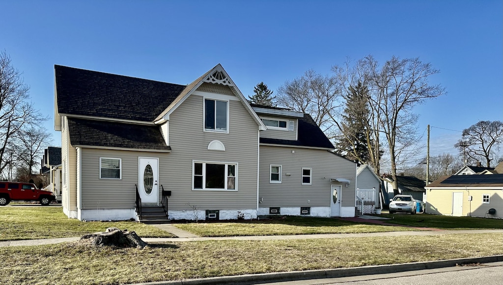 1631 Davis St, Muskegon, MI 49441 - back of property with a lawn, roof with shingles, and entry steps