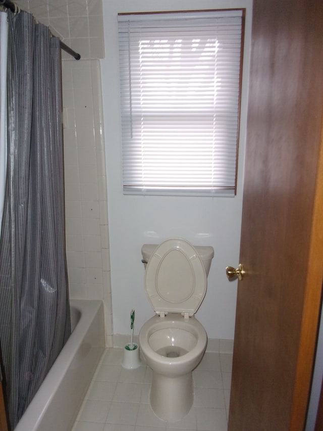 full bathroom featuring tile patterned floors, toilet, and shower / bath combo with shower curtain