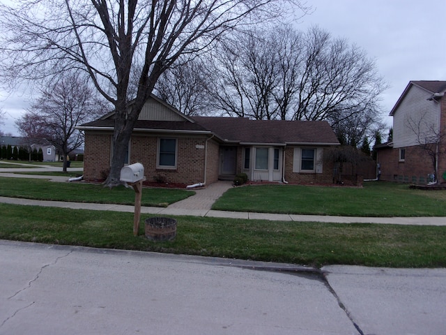 view of front facade featuring brick siding and a front lawn