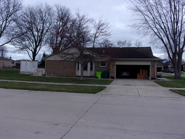 view of front facade with brick siding, driveway, a front lawn, and an attached garage