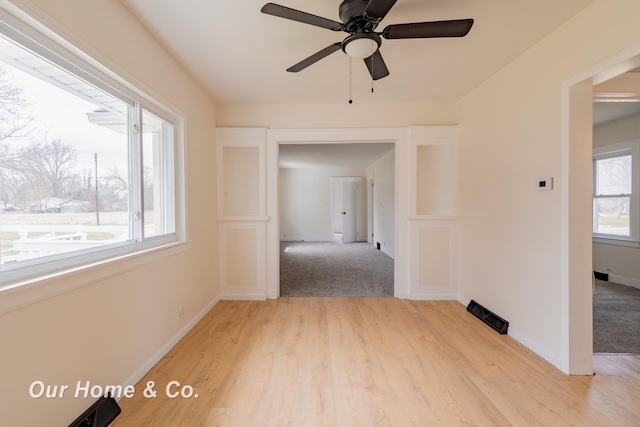 unfurnished room featuring baseboards, light wood-style floors, and a ceiling fan