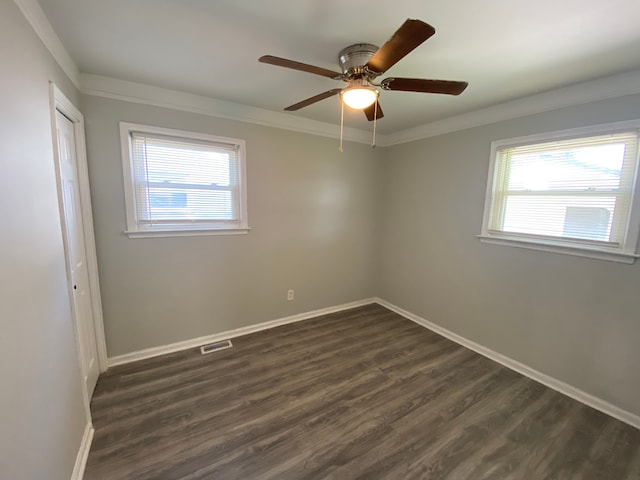 unfurnished room with baseboards, visible vents, a healthy amount of sunlight, and dark wood finished floors