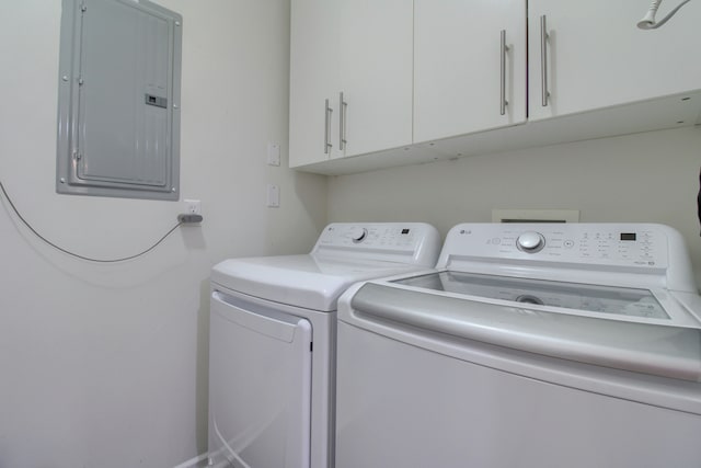 washroom with cabinet space, independent washer and dryer, and electric panel