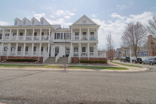 view of property with a porch and a balcony