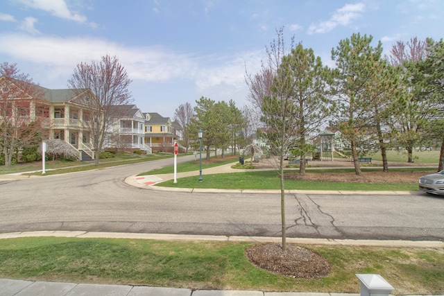 view of road with curbs, sidewalks, traffic signs, and a residential view
