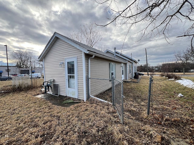 view of home's exterior with fence and a gate