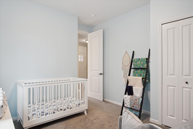 30909 Asbury Hill Ct, New Hudson, MI 48165 - bedroom with a crib, baseboards, a closet, and light colored carpet