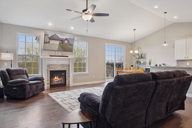 30909 Asbury Hill Ct, New Hudson, MI 48165 - living room with dark wood-style flooring, a stone fireplace, ceiling fan with notable chandelier, and lofted ceiling