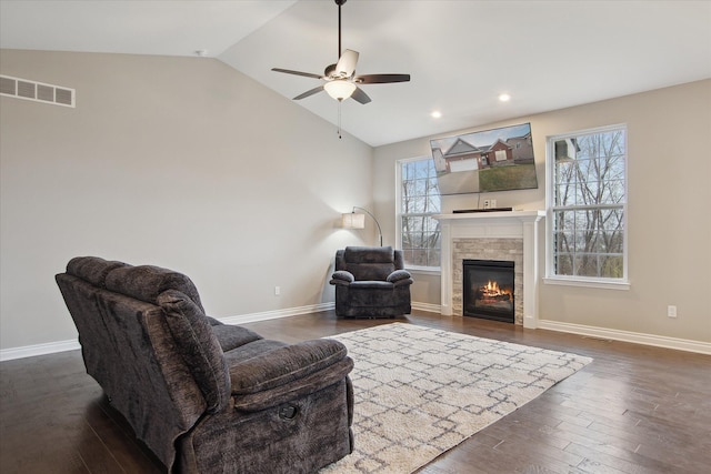 30909 Asbury Hill Ct, New Hudson, MI 48165 - living area featuring dark wood finished floors, visible vents, a stone fireplace, and a ceiling fan