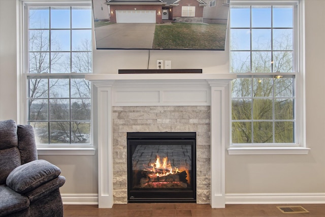 30909 Asbury Hill Ct, New Hudson, MI 48165 - details with wood finished floors, a glass covered fireplace, baseboards, and visible vents