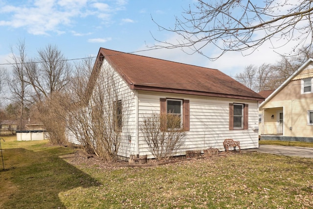 2981 Harrison St, Saginaw, MI 48604 - view of property exterior with a covered pool, a shingled roof, and a lawn
