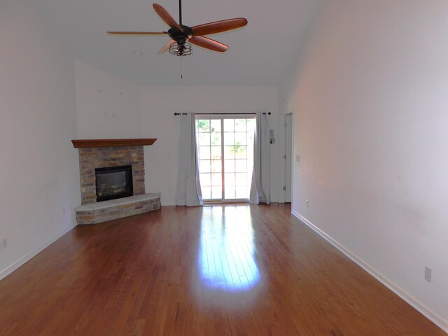 2535 Holiday House Rd Unit 24, Saint Joseph, MI 49085 - unfurnished living room with ceiling fan, wood finished floors, a stone fireplace, baseboards, and high vaulted ceiling