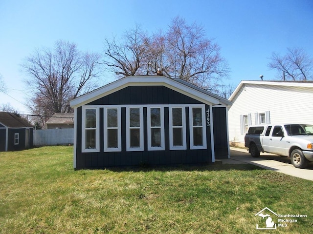 4393 2nd St, Newport, MI 48166 - rear view of house with a lawn, fence, and an outbuilding