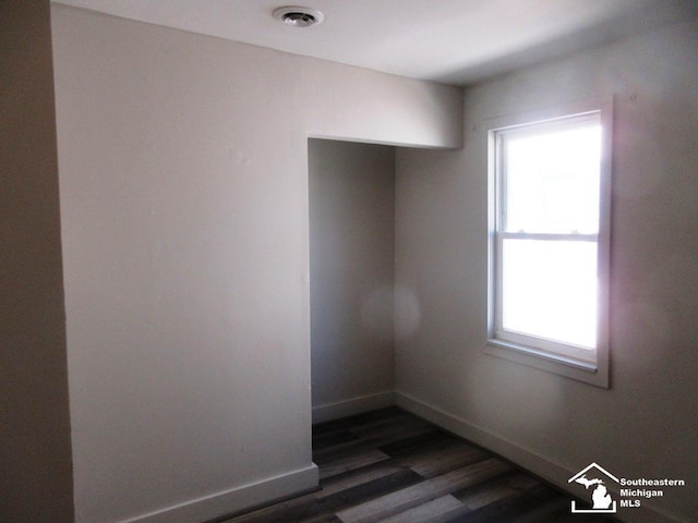 4393 2nd St, Newport, MI 48166 - empty room featuring dark wood-type flooring, visible vents, baseboards, and plenty of natural light