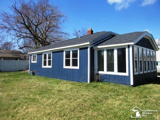 4393 2nd St, Newport, MI 48166 - back of house featuring a sunroom, a chimney, fence, and a lawn