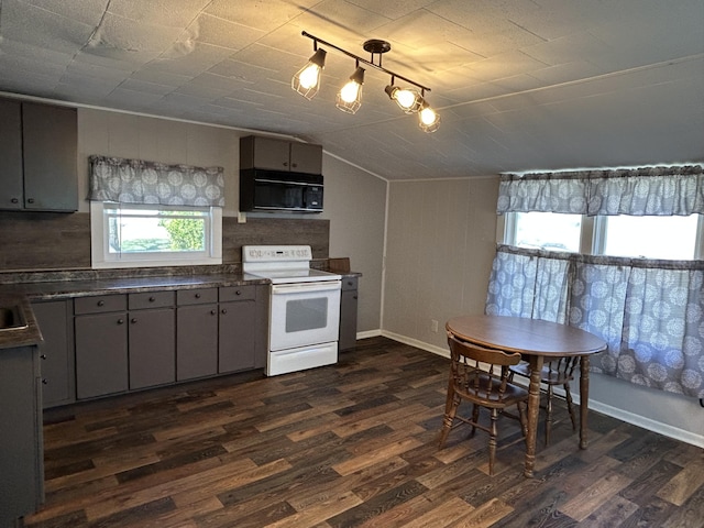 kitchen featuring black microwave, dark countertops, white electric range, and dark wood-type flooring