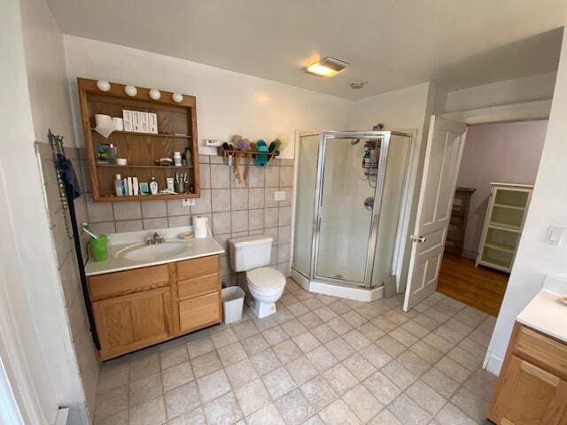 227 Railroad St, Chelsea, MI 48118 - full bathroom featuring vanity, a shower stall, tile walls, and toilet