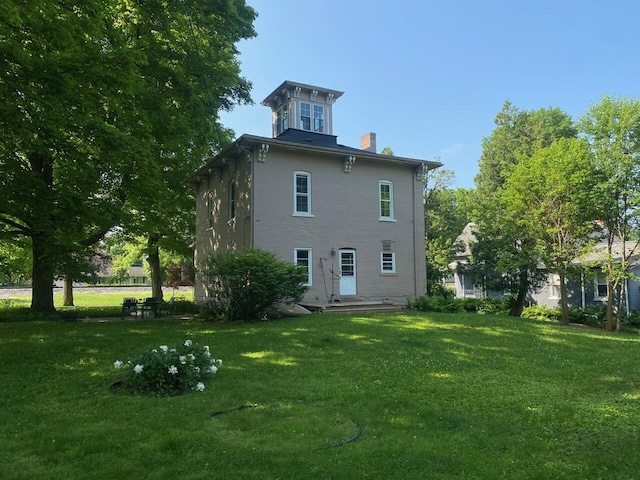 227 Railroad St, Chelsea, MI 48118 - rear view of house featuring a chimney and a yard
