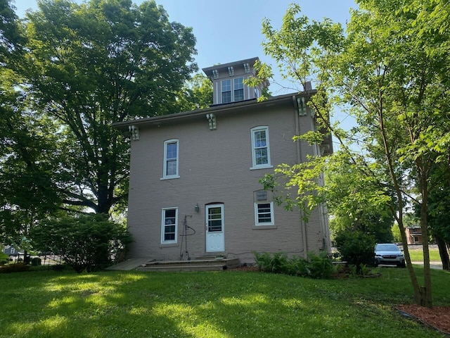 227 Railroad St, Chelsea, MI 48118 - rear view of house featuring a lawn and brick siding