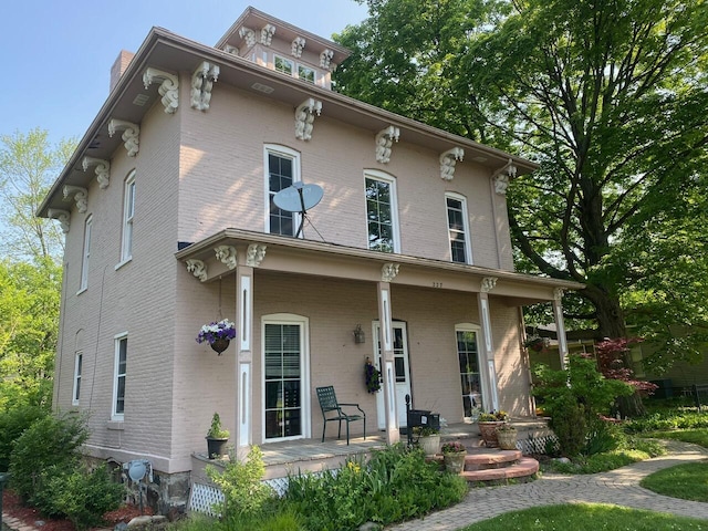 227 Railroad St, Chelsea, MI 48118 - italianate-style house featuring a porch, brick siding, and a chimney