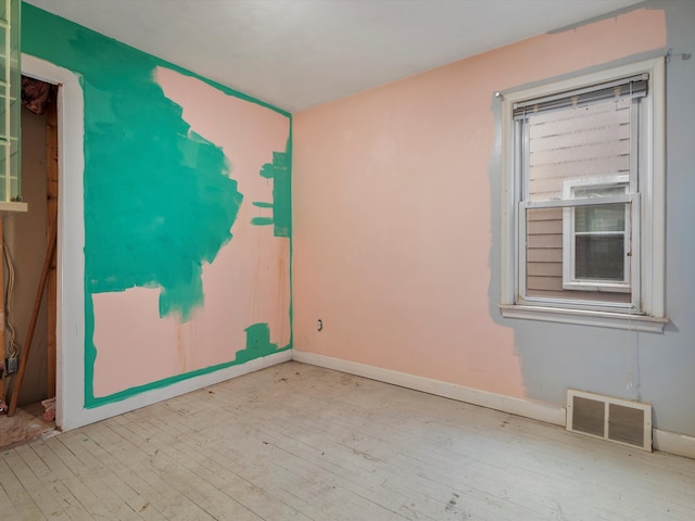 spare room with visible vents, hardwood / wood-style flooring, and baseboards