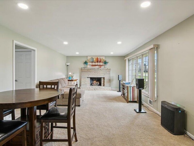 dining room featuring recessed lighting, baseboards, visible vents, light carpet, and a fireplace