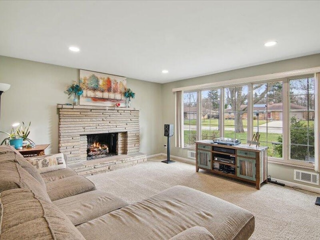 living room featuring baseboards, recessed lighting, carpet, and a stone fireplace