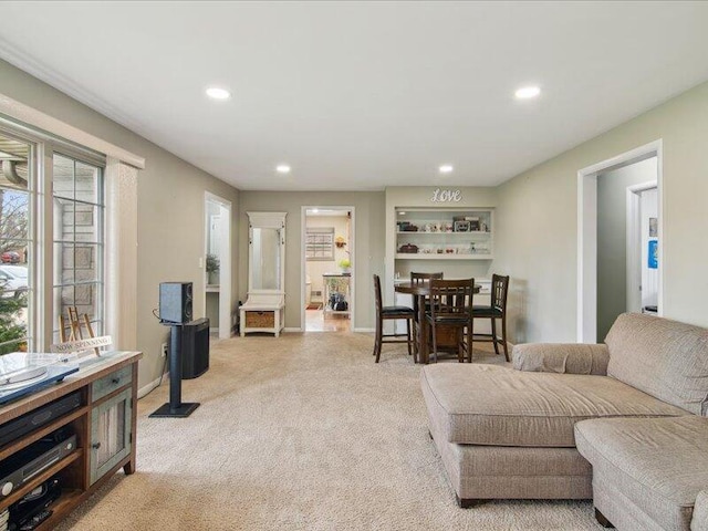 living room with baseboards, recessed lighting, and light colored carpet
