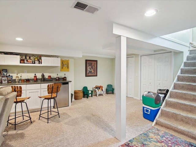 bar with stairway, light carpet, visible vents, a dry bar, and recessed lighting
