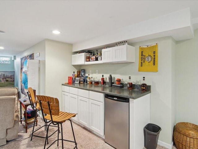bar with indoor wet bar, recessed lighting, and refrigerator