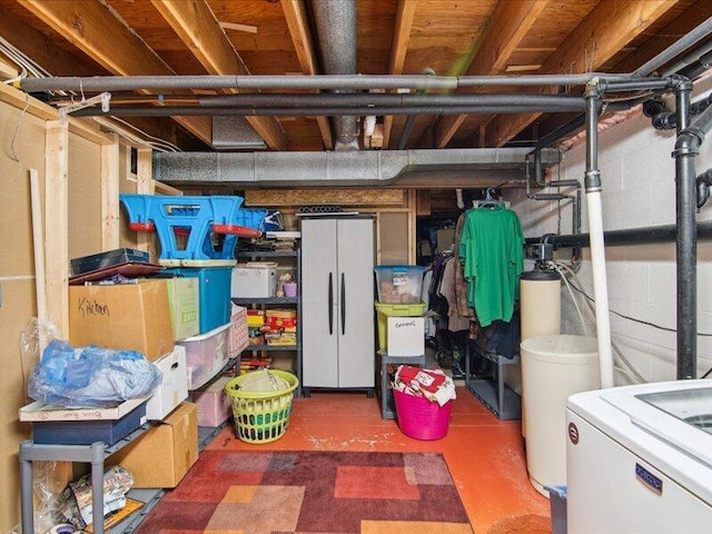 unfinished basement featuring washer / clothes dryer and concrete block wall