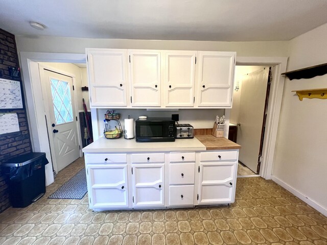 4480 Stanton Blvd, Montague, MI 49437 - kitchen featuring baseboards, white cabinets, black microwave, and light countertops