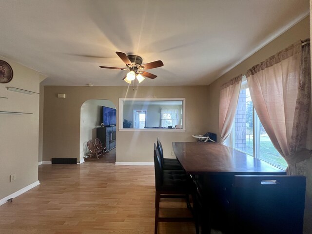 4480 Stanton Blvd, Montague, MI 49437 - dining area featuring light wood-style flooring, baseboards, arched walkways, and a ceiling fan
