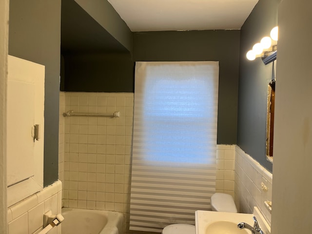 bathroom featuring vanity, a wainscoted wall, toilet, and tile walls