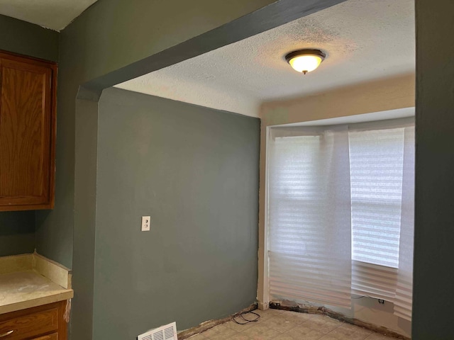 interior space with a textured ceiling and visible vents