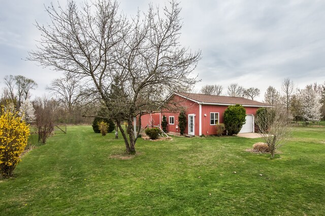 view of yard with a garage and driveway