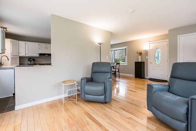 living area featuring baseboards and light wood-style flooring