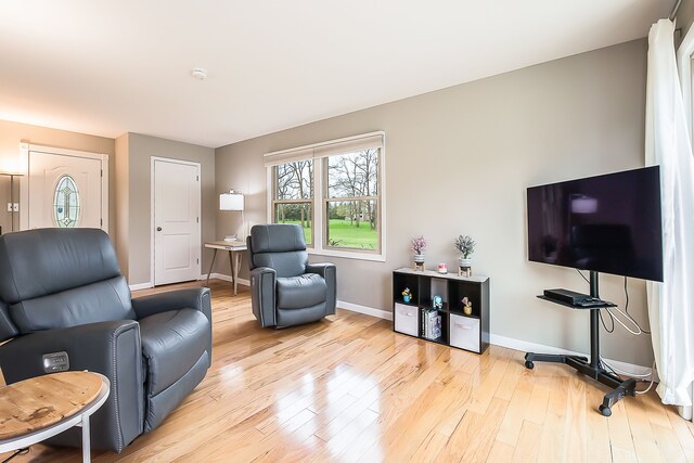 living area featuring baseboards and wood finished floors