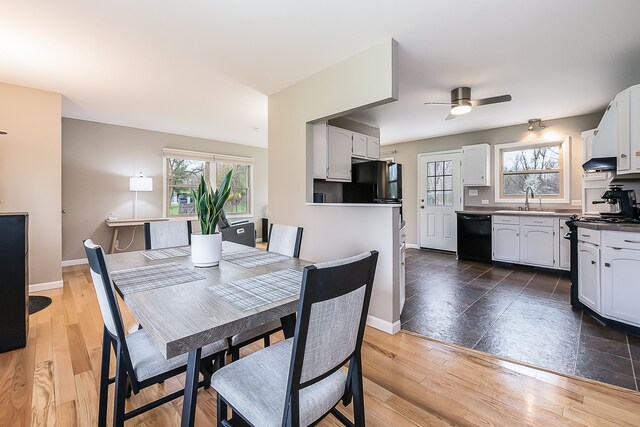 dining area featuring baseboards, ceiling fan, and light wood finished floors