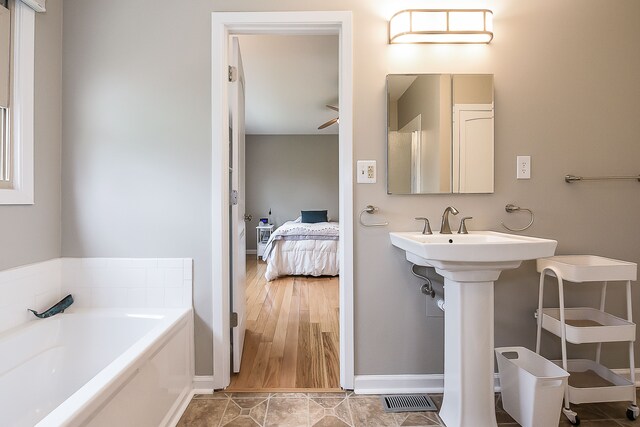 full bath with baseboards, ensuite bathroom, a garden tub, and visible vents