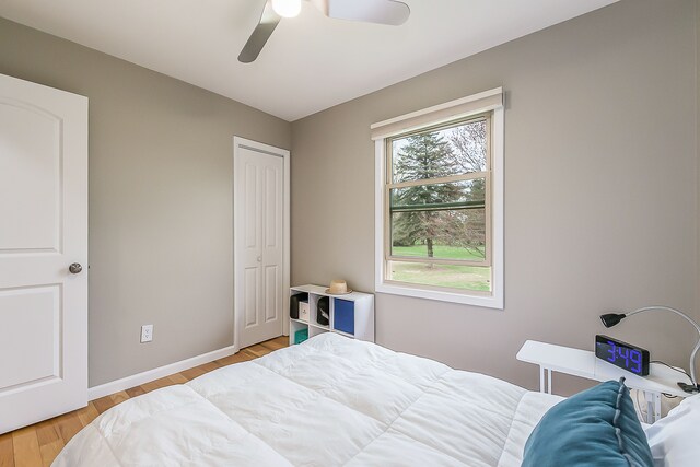 bedroom featuring baseboards, a ceiling fan, and light wood finished floors