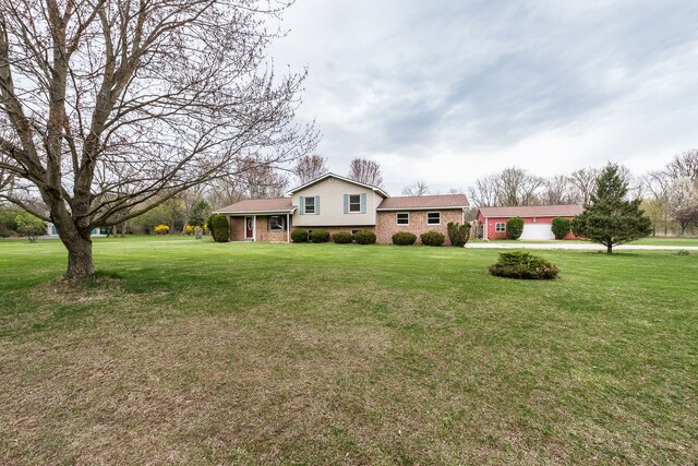 tri-level home featuring brick siding and a front yard