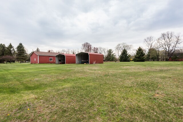view of yard featuring an outdoor structure and a detached carport