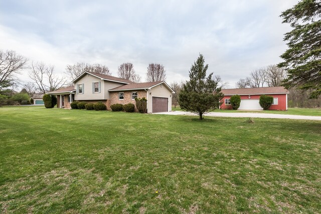 tri-level home featuring brick siding, a garage, a front yard, and concrete driveway