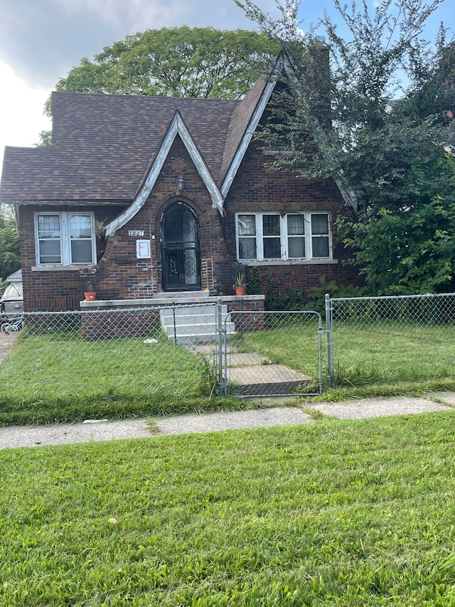 13127 Mendota St, Detroit, MI 48238 - english style home featuring a gate, a chimney, a front lawn, and a fenced front yard