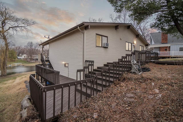 property exterior at dusk featuring a wooden deck